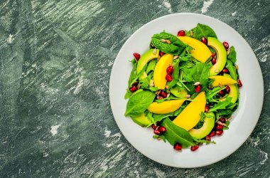 Arugula, ıspanak, dilimlenmiş mango ve avokado, nar ve ayçiçeği tohumu ile taze vegan salata