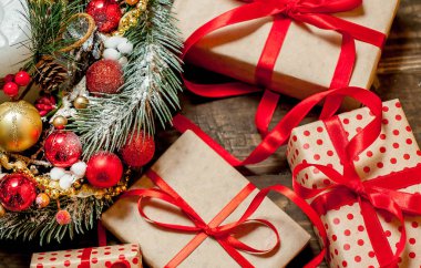 Eski ahşap arka plan üzerinde dekor ile kırmızı yay ve köknar çelenk ile hediye kutuları Yığını 