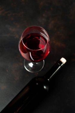Siyah arka planda kırmızı şarap ve şarap şişesi bir bardak