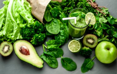 Gri arka planda sebze ve meyve ile Taze yeşil smoothie