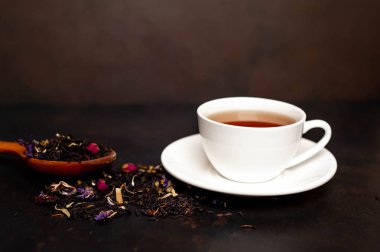 siyah arka plan üzerinde çiçek demlemek yığını ile taze çay fincan