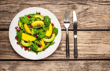 Arugula, ıspanak, dilimlenmiş mango ve avokado, nar ve ayçiçeği tohumu ile taze vegan salata