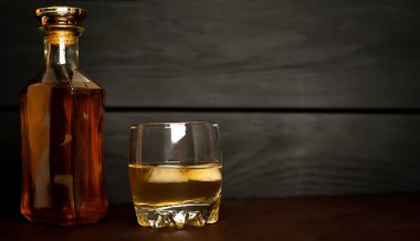 Siyah arka planda buz küpleri ve viski şişesi ile viski Bir bardak 