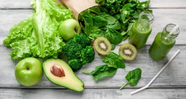 Gri arka planda sebze ve meyve ile Taze yeşil smoothie