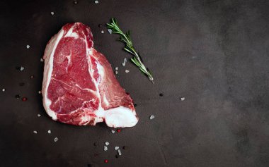 Biberiye dal, tuz ve biberiye siyah taş arka plan taze domuz biftek 