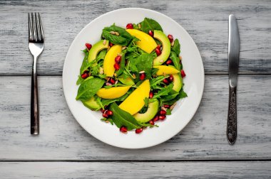 Arugula, ıspanak, dilimlenmiş mango ve avokado, nar ve ayçiçeği tohumu ile taze vegan salata
