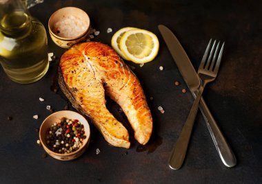 Siyah taş arka plan üzerinde baharat ve limon ile ızgara somon biftek