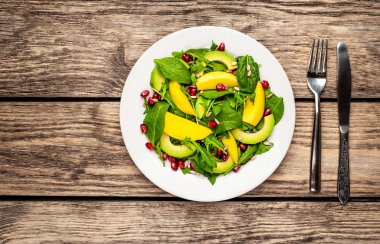 Arugula, ıspanak, dilimlenmiş mango ve avokado, nar ve ayçiçeği tohumu ile taze vegan salata