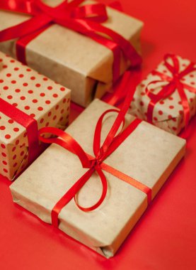 Parlak kırmızı arka plan üzerinde kırmızı yaylı hediye kutuları yığını 