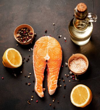 Siyah taş arka plan üzerinde baharat ve limon ile taze çiğ somon biftek
