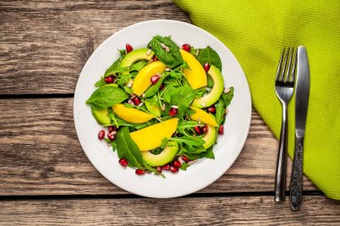 Arugula, ıspanak, dilimlenmiş mango ve avokado, nar ve ayçiçeği tohumu ile taze vegan salata