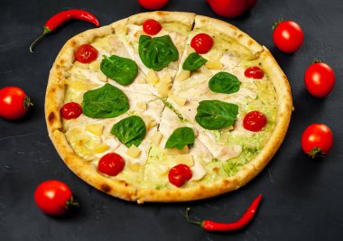 siyah taş arka plan üzerinde kiraz domates ve taze ıspanak yaprakları ile pizza