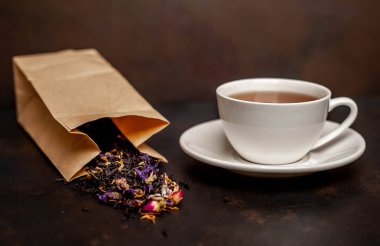 siyah arka plan üzerinde çiçek demlemek dolu kağıt torba ile taze çay fincan