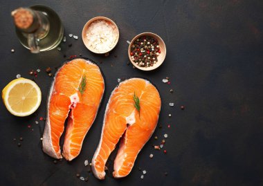 Siyah taş arka plan üzerinde baharat ve limon ile taze çiğ somon biftek