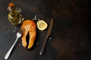Siyah taş arka plan üzerinde baharat ve limon ile ızgara somon biftek