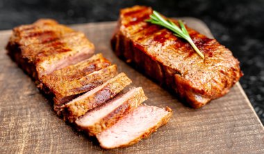 ahşap doğrama tahtası üzerinde baharat ve biberiye ile ızgara domuz biftek 