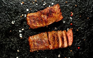 Taş siyah arka plan üzerinde baharat ile dilimlenmiş ızgara biftek yakın görünümü