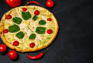 siyah taş arka plan üzerinde kiraz domates ve taze ıspanak yaprakları ile pizza