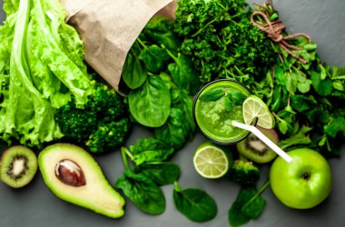 Gri arka planda sebze ve meyve ile Taze yeşil smoothie