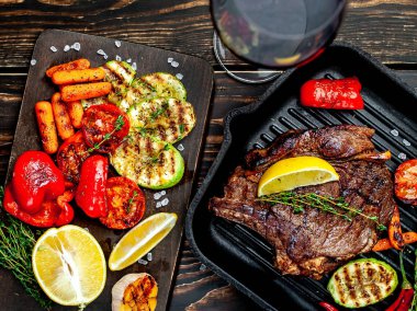 Izgara tavada ızgara sebzeler ile servis edilen taze ızgara biftek