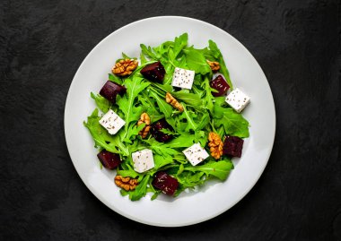 Arugula ve ıspanak ile taze salata, dilimlenmiş pancar, beyaz peynir ve ceviz