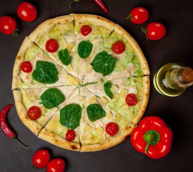 siyah taş arka plan üzerinde kiraz domates ve taze ıspanak yaprakları ile pizza