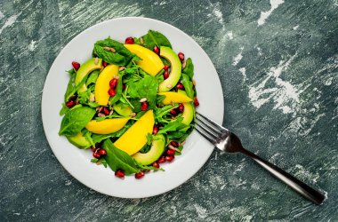 Arugula, ıspanak, dilimlenmiş mango ve avokado, nar ve ayçiçeği tohumu ile taze vegan salata