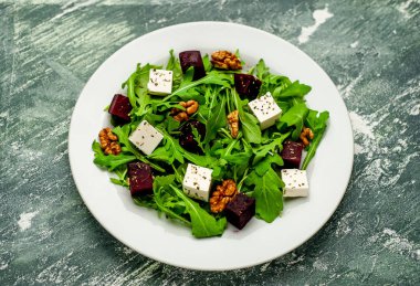 Arugula ve ıspanak ile taze salata, dilimlenmiş pancar, beyaz peynir ve ceviz