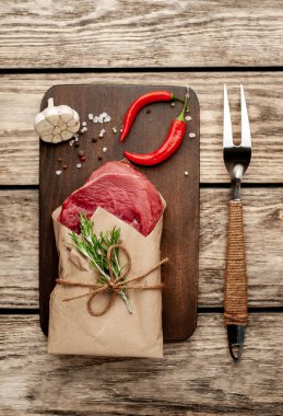 ahşap arka plan üzerinde zanaat kağıt sarılmış baharat ile biftek 