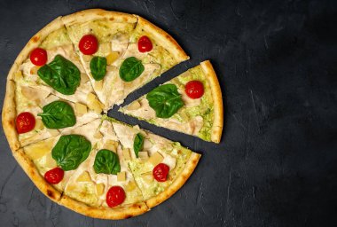 siyah taş arka plan üzerinde kiraz domates ve taze ıspanak yaprakları ile pizza