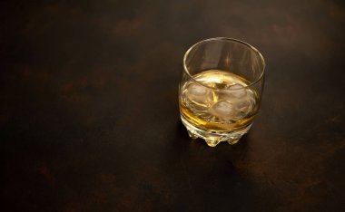 Siyah arka planda bir bardak buz viskisi
