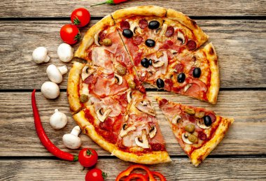 Ahşap arka plan üzerinde mantar, domates, zeytin ve jambon ile taze ev yapımı pizza