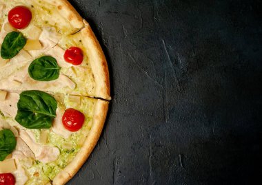 siyah taş arka plan üzerinde kiraz domates ve taze ıspanak yaprakları ile pizza