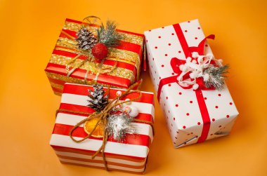 Parlak sarı arka plan üzerinde kırmızı yaylı hediye kutuları yığını 