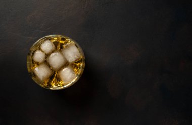 Siyah arka planda bir bardak buz viskisi