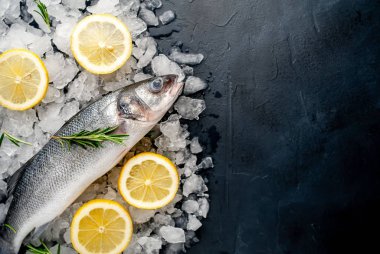 Soğuk ezilmiş buz yığını üzerinde limon dilimleri ve biberiye ile taze balık yakın görünümü