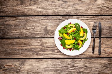 Arugula, ıspanak, dilimlenmiş mango ve avokado, nar ve ayçiçeği tohumu ile taze vegan salata