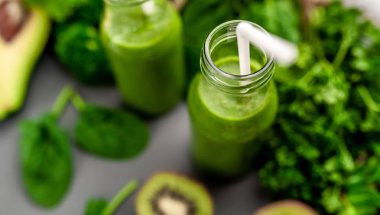 Gri arka planda sebze ve meyve ile Taze yeşil smoothie