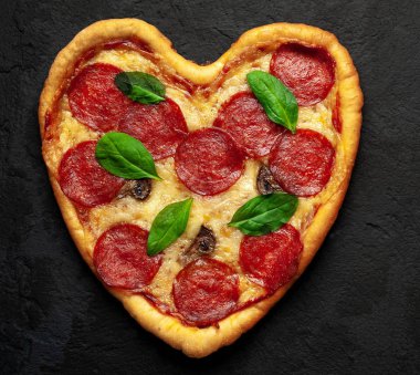 salam ve taze fesleğen yaprakları taş siyah arka plan peynir kalp pizza 