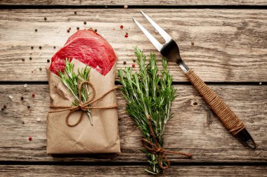 ahşap arka plan üzerinde zanaat kağıt sarılmış baharat ile biftek 