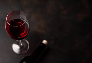 Siyah arka planda kırmızı şarap ve şarap şişesi bir bardak