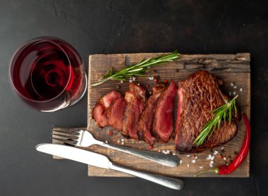 ahşap tahta üzerinde orta nadir sığır biftek kırmızı şarap cam ile servis