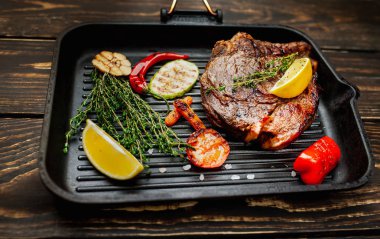 Izgara tavada biberiye ve sebze ile Taze ızgara domuz biftek 