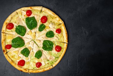 siyah taş arka plan üzerinde kiraz domates ve taze ıspanak yaprakları ile pizza