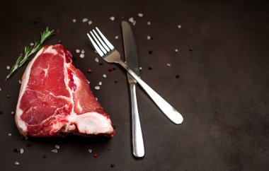 Taş arka planda baharat ve biberiye dal ile Çiğ yağ biftek