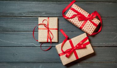 Eski ahşap arka plan üzerinde kırmızı yayile hediye kutuları yığını 