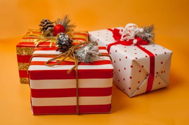 Parlak sarı arka plan üzerinde kırmızı yaylı hediye kutuları yığını 