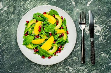 Arugula, ıspanak, dilimlenmiş mango ve avokado, nar ve ayçiçeği tohumu ile taze vegan salata