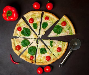 siyah taş arka plan üzerinde kiraz domates ve taze ıspanak yaprakları ile pizza