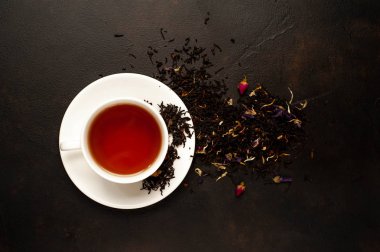 siyah arka plan üzerinde çiçek demlemek yığını ile taze çay fincan